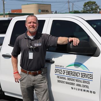 Chris Newkirk next to an Emergency Services truck